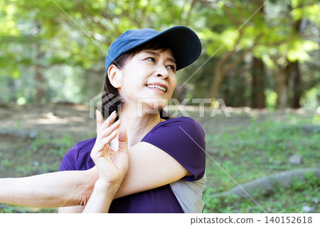 Middle-aged women stretching outdoors Middle-aged women stretching outdoors 140152618