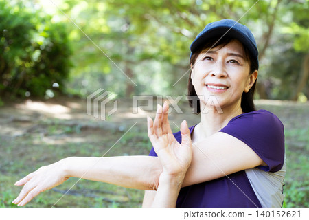 Middle-aged women stretching outdoors Middle-aged women stretching outdoors 140152621