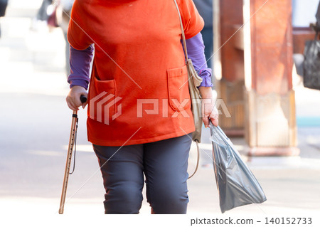 An old man walking with a cane An old man walking with a cane 140152733