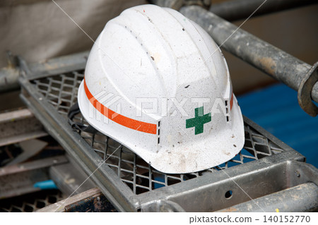Exterior painting, helmets placed on scaffolding at a construction site. An image of construction workers. Exterior painting, helmets placed on scaffolding at a construction site. An image of construction workers. 140152770