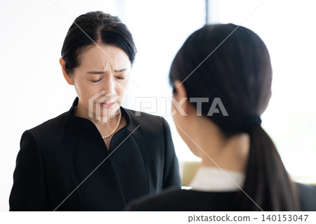 Mourners grieving at the funeral. Mourners grieving at the funeral. 140153047