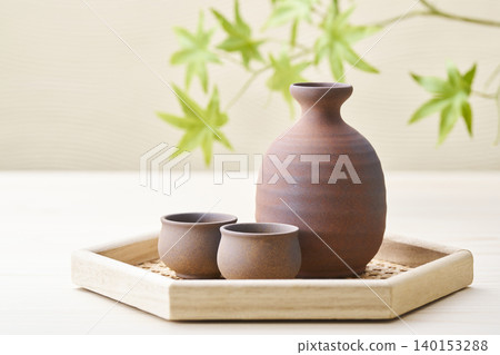 A sake set featuring a sake cup and carafe, representing the image of Japanese sake. A sake set featuring a sake cup and carafe, representing the image of Japanese sake. 140153288