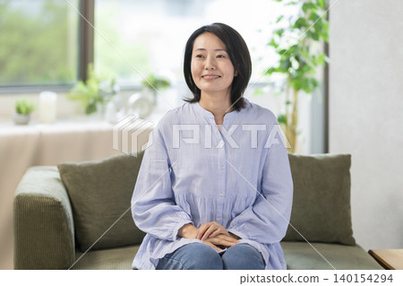 一位四十多歲、微笑的女士 一位四十多歲、微笑的女士 140154294