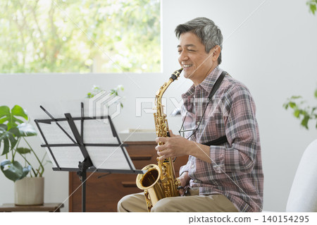 A man in his 60s playing the saxophone. A man in his 60s playing the saxophone. 140154295