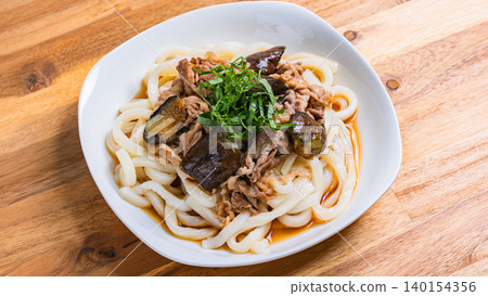 一張涼拌烏龍麵的照片,配上茄子和豬肉,上面撒著紫蘇葉,非常適合夏天食用。 一張涼拌烏龍麵的照片,配上茄子和豬肉,上面撒著紫蘇葉,非常適合夏天食用。 140154356