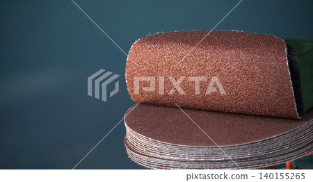 Stack of round sandpaper discs for orbital sander, close-up detail Stack of round sandpaper discs for orbital sander, close-up detail 140155265