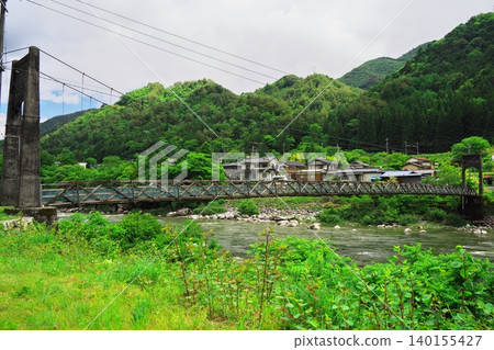 Morohara Bridge, a suspension bridge spanning the Kiso River, surrounded by fresh greenery. Morohara Bridge, a suspension bridge spanning the Kiso River, surrounded by fresh greenery. 140155427