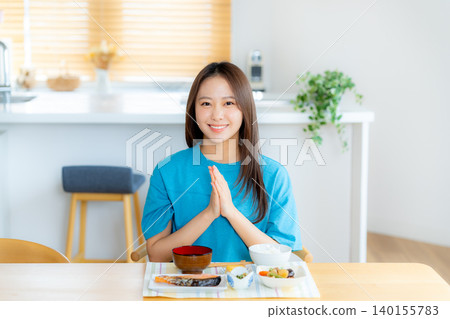 一個年輕的女人吃飯 一個年輕的女人吃飯 140155783