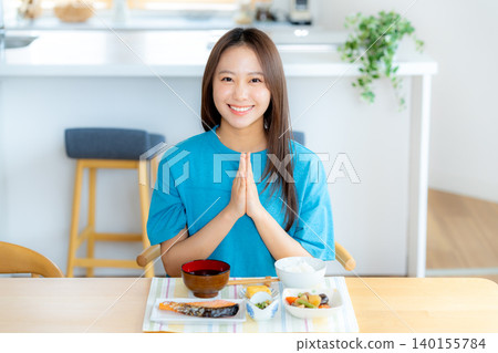 一個年輕的女人吃飯 一個年輕的女人吃飯 140155784
