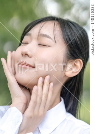 A woman's profile as she takes a deep breath in the sunlight. (Advertisement material for organic skincare products) A woman's profile as she takes a deep breath in the sunlight. (Advertisement material for organic skincare products) 140156388