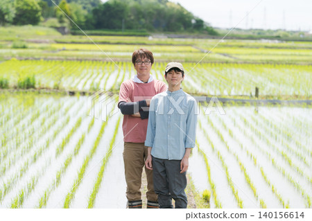 Two rice farmers smiling in a rice field. Two rice farmers smiling in a rice field. 140156614