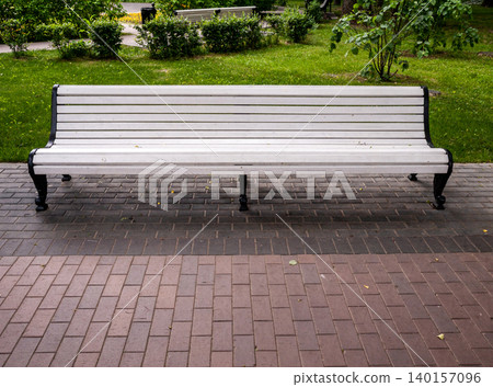 Classical white wooden bench in a green park under gentle semi shade. Classical white wooden bench in a green park under gentle semi shade. 140157096