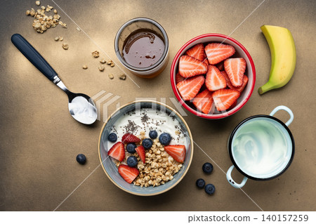 Preparing healthy breakfast yogurt berries granola Preparing healthy breakfast yogurt berries granola 140157259