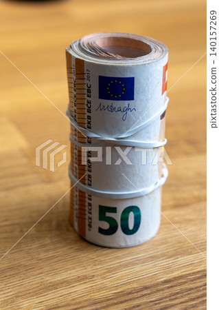 Vertical shot of 50 Euro banknotes roll tied with rubber band 140157269