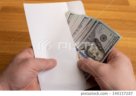 Hands holding envelope with US dollar cash, bribery or illegal payment concept Hands holding envelope with US dollar cash, bribery or illegal payment concept 140157287