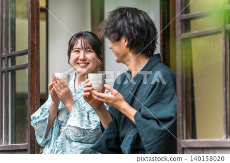 Couples enjoying tea on the veranda of a hot spring inn, temple lodging, or old farmhouse during their trip. Couples enjoying tea on the veranda of a hot spring inn, temple lodging, or old farmhouse during their trip. 140158020