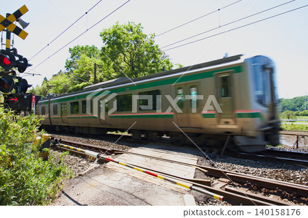 A railway crossing in rural Japan, with a train present. A railway crossing in rural Japan, with a train present. 140158176