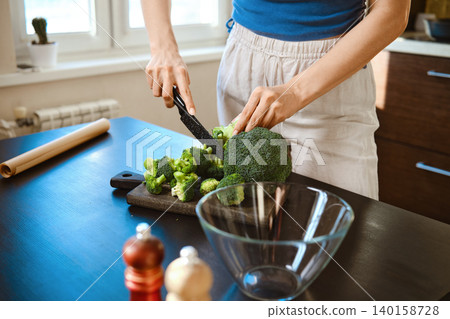 Smashed broccoli with cheese preparation in a bright kitchen during afternoon cooking session Smashed broccoli with cheese preparation in a bright kitchen during afternoon cooking session 140158728