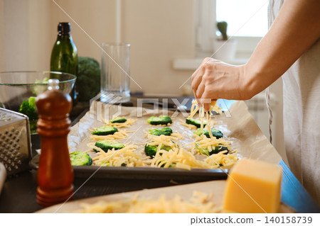 Preparation of smashed broccoli with cheese in a bright kitchen setting during the day Preparation of smashed broccoli with cheese in a bright kitchen setting during the day 140158739