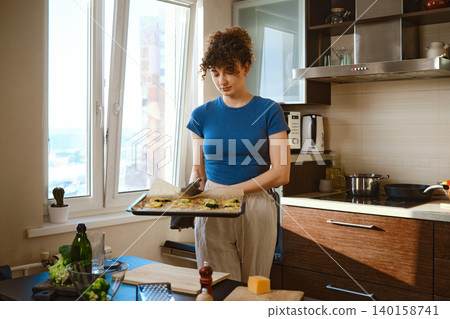Preparing smashed broccoli with cheese in a kitchen during daytime with a sunny view Preparing smashed broccoli with cheese in a kitchen during daytime with a sunny view 140158741