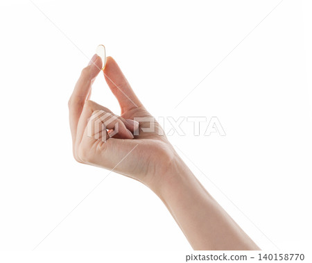 Female hand hold transparent pill isolated on white Female hand hold transparent pill isolated on white 140158770