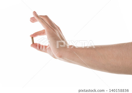 Male hand show brown pill isolated on white Male hand show brown pill isolated on white 140158836