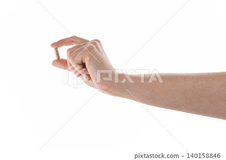 Female hand hold beige pill isolated on white Female hand hold beige pill isolated on white 140158846