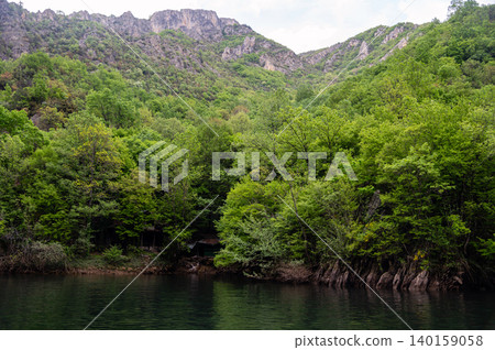 Visitors admire Matka Canyons natural beauty, surrounded by trees and water. 140159058