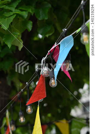 Colorful bunting and string lights in garden 140159294