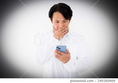 A casually dressed middle-aged man is shocked when he looks at his smartphone. A casually dressed middle-aged man is shocked when he looks at his smartphone. 140160409