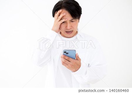 A casually dressed middle-aged man is shocked when he looks at his smartphone. A casually dressed middle-aged man is shocked when he looks at his smartphone. 140160460