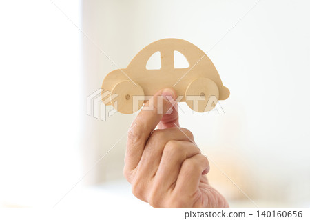 An Asian senior offers a car-shaped ornament. 140160656