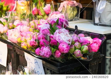 Fresh pink peony bouquets on a flower shop shelf in Hong Kong with a handwritten price tag indicating large peonies Fresh pink peony bouquets on a flower shop shelf in Hong Kong with a handwritten price tag indicating large peonies 140160820