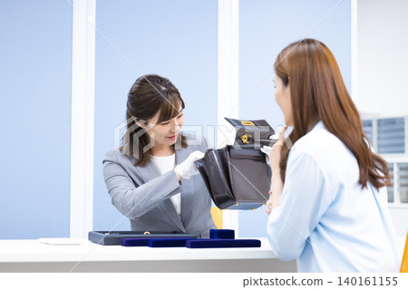 一位女士在採購公司的櫃檯評估一件商品 一位女士在採購公司的櫃檯評估一件商品 140161155