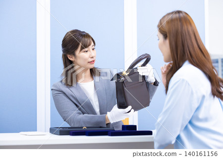 一位女士在採購公司的櫃檯評估一件商品 一位女士在採購公司的櫃檯評估一件商品 140161156