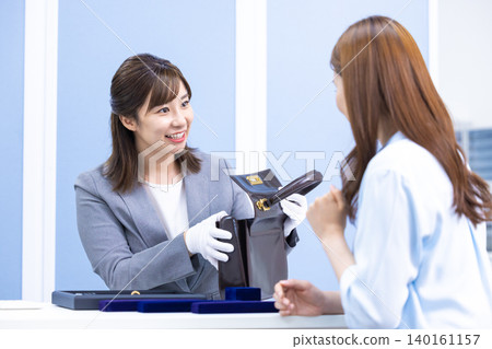 A woman assessing an item at a purchasing company's counter A woman assessing an item at a purchasing company's counter 140161157