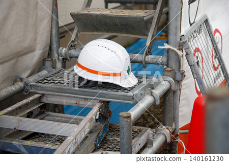 A helmet rests on the scaffolding used for exterior wall painting. A helmet rests on the scaffolding used for exterior wall painting. 140161230