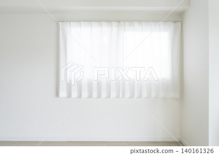 Light streams in through the lace curtains from the window, against the white wall. Light streams in through the lace curtains from the window, against the white wall. 140161326