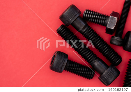 Hexagonal bolt and nut on a red background 140162197