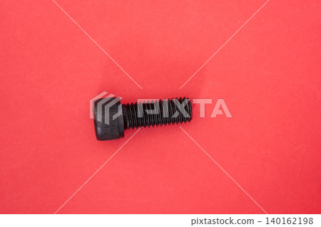 Hexagonal bolt and nut on a red background Hexagonal bolt and nut on a red background 140162198