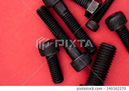 Hexagonal bolt and nut on a red background 140162270