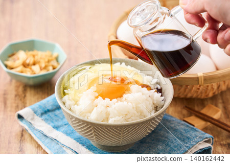 Egg over rice: A breakfast of white rice and a raw egg served in a bowl. Egg over rice: A breakfast of white rice and a raw egg served in a bowl. 140162442