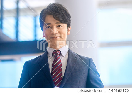 一位身著西裝、面帶溫和微笑的商人。 一位身著西裝、面帶溫和微笑的商人。 140162570