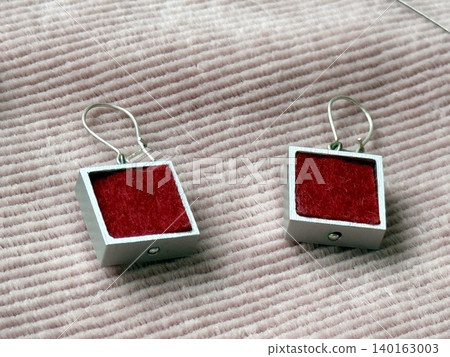 Red velvet square earrings on textured pink fabric background for jewelry fashion accessory style 140163003