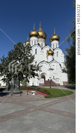 Cathedral with golden domes against clear blue sky, trees and paved square in foreground Cathedral with golden domes against clear blue sky, trees and paved square in foreground 140163232