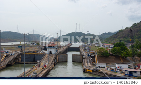 Colon, Panama - May 06, 2019: Waterway transportation. Ship at Gatun lake on the Panama canal. Waterway for sea ship transport. Opening gateway. Transport passing through Panama Canal Colon, Panama - May 06, 2019: Waterway transportation. Ship at Gatun lake on the Panama canal. Waterway for sea ship transport. Opening gateway. Transport passing through Panama Canal 140163840