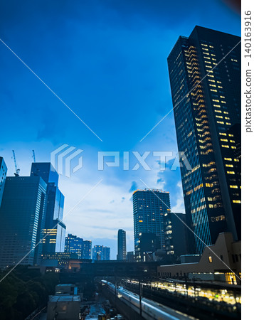 The Tokyo skyline at dusk, with the Shinkansen bullet train speeding by, radiating light – a beautiful night view. The Tokyo skyline at dusk, with the Shinkansen bullet train speeding by, radiating light – a beautiful night view. 140163916