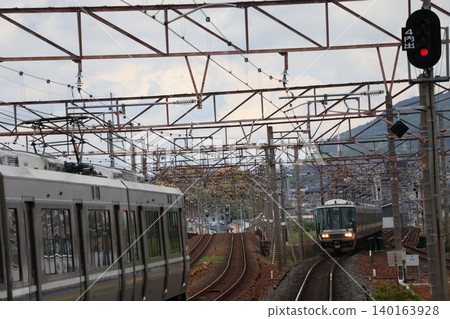 A scene of train tracks with train cars passing by. A scene of train tracks with train cars passing by. 140163928