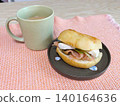 A table with a salmon sandwich and milk coffee. 140164636