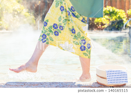 The feet of a woman in a yukata who puts her feet in an open-air bath. 140165515
